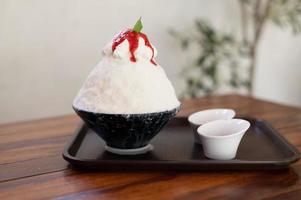 dessert coréen à la glace pilée avec garnitures sucrées, bingsu aux fraises sur table en bois photo