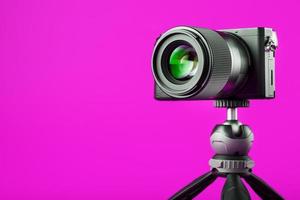 appareil photo professionnel sur trépied, sur fond rose. enregistrer des vidéos et des photos pour votre blog ou rapport.