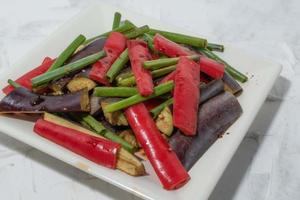 aubergines frites dans une assiette sur fond blanc. photo