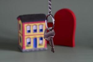 symbole de maison avec clé en métal et miniature de propriété, symbolisant l'accession à la propriété photo