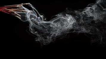 illustration créative de l'arôme du bâton d'encens avec de la fumée isolée sur fond noir photo