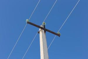 ligne électrique à haute tension. support de ligne électrique et fils contre le ciel bleu. photo