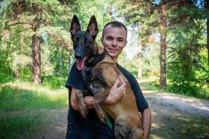 le jeune hipster caucasien passe du temps avec son chien dans le parc par une journée d'été ensoleillée. le concept d'un animal de compagnie en tant que membre de la famille photo