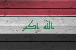 drapeau irakien représenté dans des couleurs de peinture vives sur un vieux mur en bois. bannière texturée sur fond rugueux photo