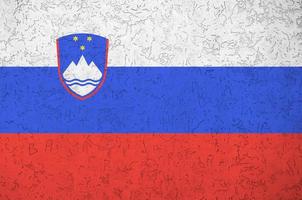 drapeau de la slovénie représenté dans des couleurs de peinture vives sur un vieux mur de plâtrage en relief. bannière texturée sur fond rugueux photo
