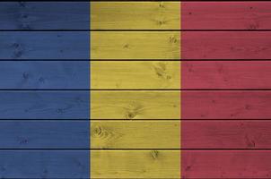 drapeau de la roumanie représenté dans des couleurs de peinture vives sur un vieux mur en bois. bannière texturée sur fond rugueux photo