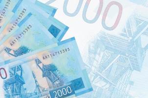 Les billets de 2000 roubles russes sont empilés sur fond de gros billets semi-transparents. arrière-plan abstrait des affaires photo