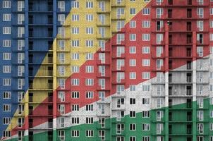 drapeau des seychelles représenté dans des couleurs de peinture sur un immeuble résidentiel à plusieurs étages en construction. bannière texturée sur fond de mur de brique photo