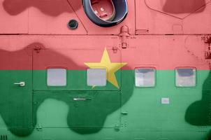 drapeau du burkina faso représenté sur la partie latérale d'un gros plan d'hélicoptère blindé militaire. arrière-plan conceptuel des avions des forces armées photo