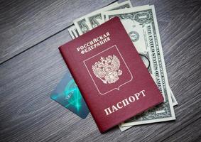 un passeport étranger et des dollars sur un fond en bois. photo
