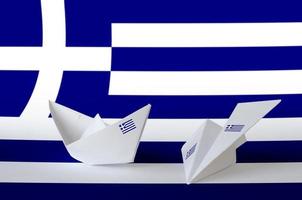 drapeau de la grèce représenté sur un avion et un bateau en papier origami. concept d'art fait à la main photo