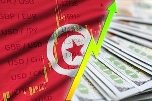 drapeau de la tunisie et graphique augmentant la position du dollar américain avec un fan de billets d'un dollar photo