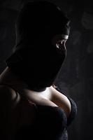 portrait d'une jeune fille dans une cagoule noire et un soutien-gorge noir. photo