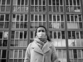 photo d'une fille masquée, dans la rue. confinement covid-19 pandémie.