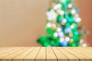 dessus de table en bois vide avec arbre de noël flou avec fond clair bokeh photo