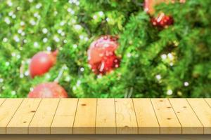 dessus de table en bois vide avec arbre de noël flou avec fond clair bokeh photo