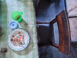 la table à manger est en désordre. une table à manger en désordre avec de la vaisselle usagée et pleine de restes de nourriture qui n'ont pas été nettoyés. vrai vie. fin de l'année photo