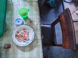 la table à manger est en désordre. une table à manger en désordre avec de la vaisselle usagée et pleine de restes de nourriture qui n'ont pas été nettoyés. vrai vie. fin de l'année photo