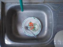 vaisselle et verres sales dans l'évier qui n'ont pas été lavés. des tas de vaisselle sale et des verres pas lavés, la vraie vie à la fin de l'année photo