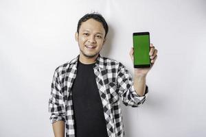 un portrait d'un homme asiatique heureux sourit tout en montrant un espace de copie sur son téléphone, isolé sur fond blanc photo