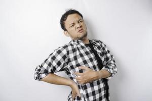 jeune homme fatigué et bouleversé souffrant de maux de dos, de spasmes musculaires sur le lieu de travail. fatigue, délai, douleur et posture incorrecte photo