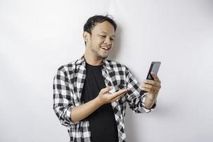 un portrait d'un homme asiatique heureux sourit tout en tenant son téléphone, isolé sur fond blanc photo