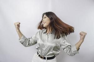 une jeune femme asiatique avec une expression heureuse et réussie portant une chemise vert sauge isolée par fond blanc photo