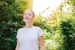 jeune femme souriante en plein air. belle fille brunete reposant sur fond vert parc ou jardin. femme heureuse libre en été. liberté bonheur insouciant concept de gens heureux. photo