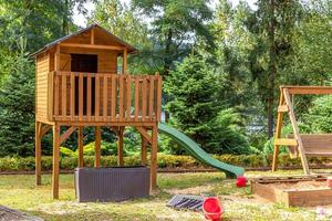 aire de jeux pour enfants en bois moderne vide située sur une cour verte dans un parc public en été. terrain de jouets amusant pour les enfants. activités d'exercice urbain pour enfant à l'extérieur. concept d'enfance de quartier. photo