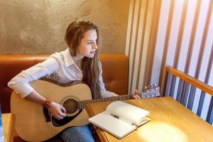 jeune fille jouant de la guitare au café photo