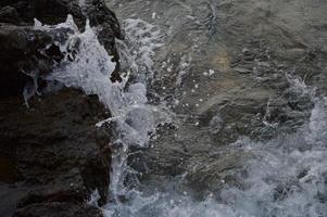 vagues de la mer se brisant sur les rochers photo