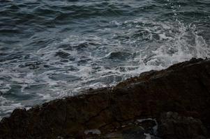 vagues de la mer se brisant sur les rochers. photo