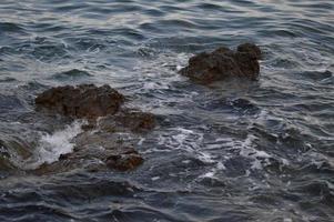 vagues de la mer se brisant sur les rochers. photo