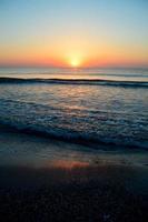 beau coucher de soleil d'été sur la plage, les vagues et le sable photo