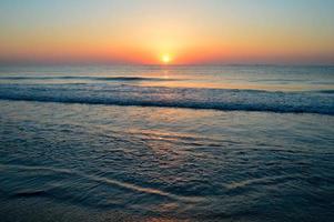 beau coucher de soleil d'été sur la plage, les vagues et le sable photo