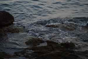 vagues de la mer se brisant sur les rochers photo