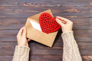 fille tenant une enveloppe avec des coeurs de la Saint-Valentin. concept de saint valentin avec fond photo