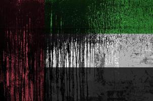 drapeau des émirats arabes unis représenté dans des couleurs de peinture sur un gros plan de mur de baril de pétrole vieux et sale. bannière texturée sur fond rugueux photo