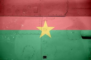 drapeau du burkina faso représenté sur la partie latérale d'un gros plan d'hélicoptère blindé militaire. arrière-plan conceptuel des avions des forces armées photo