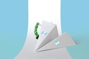 drapeau du guatemala représenté sur un avion en papier origami. concept d'art fait à la main photo