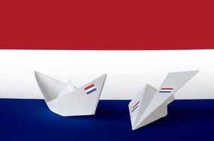 drapeau des pays-bas représenté sur un avion et un bateau en papier origami. concept d'art fait à la main photo