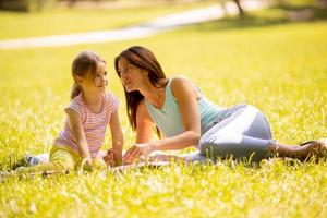 mère avec petite fille s'amusant dans le parc par une journée ensoleillée photo
