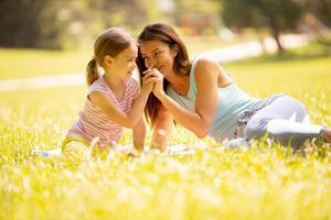 mère avec petite fille s'amusant dans le parc par une journée ensoleillée photo