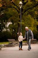 grand-père passe du temps avec sa petite-fille dans le parc le jour de l'automne photo