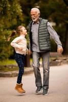 grand-père passe du temps avec sa petite-fille dans le parc le jour de l'automne photo