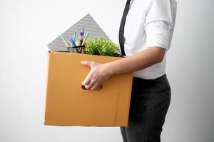 la vue de côté. l'employé a été licencié pour avoir transporté une boîte en carton marron avec son équipement. sur fond blanc. photo