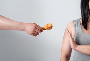 les jeunes femmes en surpoids rejettent les aliments frits. elle perd du poids sur un fond blanc. photo