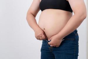 les femmes en surpoids portent des jeans sur fond blanc dans le studio. photo