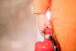 se concentrer sur l'extincteur, l'homme a porté l'extincteur pour éteindre le feu dans le bâtiment. photo