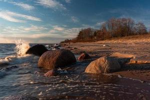 pierres sur la côte de la mer baltique au coucher du soleil photo